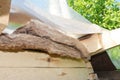 Roofing construction on the stage of glass wool batt insulation which is temporary covered with plastic film from rainy weather