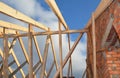 Roofing construction on the stage of roof framing. A close-up of wooden roof framing with roof beams, trusses and rafters attached Royalty Free Stock Photo