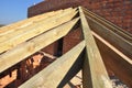 Roofing construction with trusses, wooden rafters, eaves and timber on brick house roof corner