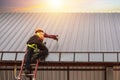 The roofing construction workers wear safety uniforms working high