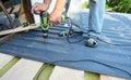 Roofing contractor installing metal roof sheets on the house rooftop