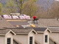 Roofing contractor removing the old shingles from a roof ready for reroofing