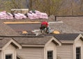 Roofing contractor removing the old shingles from a roof ready for reroofing