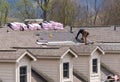 Roofing contractor removing the old shingles from a roof ready for reroofing