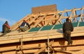 Roofing contractors installing house wooden beams framework with damp, vapor, waterproof membrane Roofing Construction