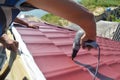 Roofing contractors installing metal roof tile for roof repair. Roofing construction Royalty Free Stock Photo