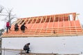 Roofing contractors installing roof boards and vapor barriers for metal tiles in winter time. Insulation of the facade house