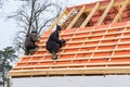 Roofing contractors installing roof boards and vapor barriers for metal tiles in winter time.