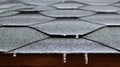 Roofing on the roof of a house or gazebo made of bituminous tiles with frozen flowing water and hanging icicles. Close-up Royalty Free Stock Photo