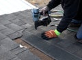 ROOFING: Worker secures a new shingle.