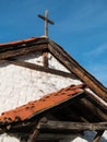 Rooflines and rustic cross on historic church