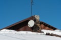 The roofs of the buildings are covered with snow and ice after a big snowfall. An old parabolic satellite TV antenna is installed