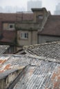 Roofs with tiles and rusty corrugated iron in rough old traditional part of Chinese city