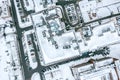 Rooftop of apartment building with ventilation systems and courtyard with parked cars covered by snow. aerial view Royalty Free Stock Photo