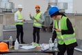 On the rooftop of construction site beautiful engineer make a conversation with some worker using the ration