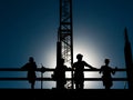 Rooftop construction workers on a break, backlit- making them shilouettes