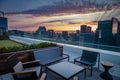 Rooftop deck with chairs overlooks the San Francisco skyline sunset with purple and gold clouds