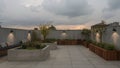 Rooftop garden with planters and seating area at dusk time Royalty Free Stock Photo
