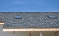 Rooftop house construction with new attic skylight windows and asphalt shingles Royalty Free Stock Photo