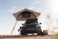 Rooftop tent for camping on the roof rack of an off-road SUV car in a desert Royalty Free Stock Photo