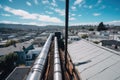 rooftop view of city, with downpipe being replaced and new pipe being installed