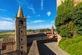Rooftops and medieval belfry under blue sky in Italy. Royalty Free Stock Photo