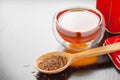 Rooibos in spoon closeup, two tea cups and tea tin box on table Royalty Free Stock Photo