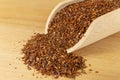 Rooibos tea medium cut in wooden scoop on wooden board. Rooibos in latin Aspalathus linearis. Royalty Free Stock Photo