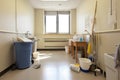 room with cleaning supplies, including mop bucket, broom, and dustpan