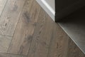 Room corner, three different textures: grey wall, natural oak wood floor, stone dark grey tiles Royalty Free Stock Photo