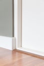 Room corner, white door, wood floor, grey wall. Royalty Free Stock Photo
