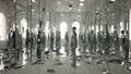 A room filled with mirrors reflecting distorted versions of the character, symbolizing the internal battle of