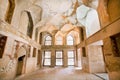 Room with fireplace and faded frescoes on the walls of historical Palace in Middle East
