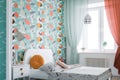 a room with a fresh wallpaper design in bold colors, complemented by pale blue walls and light furniture Royalty Free Stock Photo