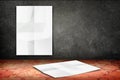 room with hanging blank crumpled white poster at black stone wall and falling poster at vintage pattern brick floor,Template Mock Royalty Free Stock Photo