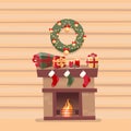 Room interior with Christmas fireplace with socks, decorations, gift boxes, candeles, socks and wreath on background of a wooden Royalty Free Stock Photo