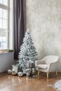 Room interior with Christmas tree, gray chair and gift boxes. Window with windowsill Royalty Free Stock Photo