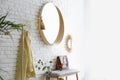 Room interior with round mirror hanging on brick wall Royalty Free Stock Photo