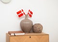 Room interior. Two vases on the chest of drawers and Danish flags and a wall clock. Royalty Free Stock Photo