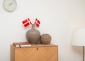 Room interior. Two vases on the chest of drawers and Danish flags and a wall clock. Royalty Free Stock Photo