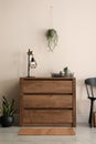 Room interior with wooden chest of drawers near wall Royalty Free Stock Photo