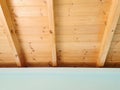 Room with light blue turquoise painted plaster walls and wooden ceiling with beams. Wooden mansard construction Royalty Free Stock Photo