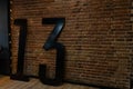 In the room near the vintage brick wall there are big black numerals 13. Original interior of the studio. Retro style.