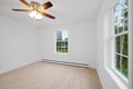 Room in a newly constructed house with white walls, a lit chandelier, and glass windows Royalty Free Stock Photo