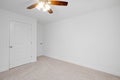 A room in a newly constructed house with white walls, a lit chandelier, and wooden doors Royalty Free Stock Photo