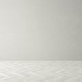 A room with a plain, light gray background and a herringbone-patterned wooden floor. Royalty Free Stock Photo