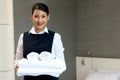 Room service maid cleaning and making bed hotel room concept, portrait of young beautiful Asian smiling female chambermaid holding