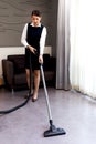 Room service maid cleaning and making bed hotel room concept, young beautiful Asian female chambermaid vacuuming the floor at Royalty Free Stock Photo