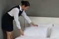 Room service maid cleaning and making bed hotel room concept, young female chambermaid making bed in hotel room Royalty Free Stock Photo