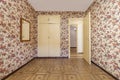 Room with walls wallpapered with vintage kitsch red flowers and cabinets